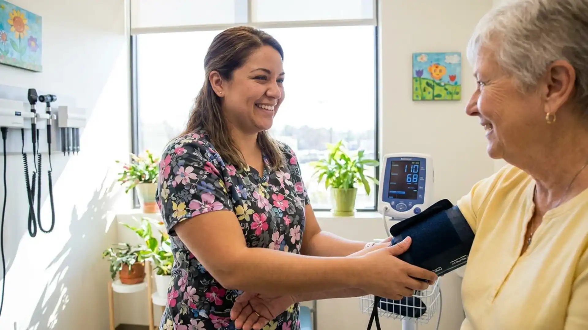 medical assistant checking patient's blood pressure in doctor's office