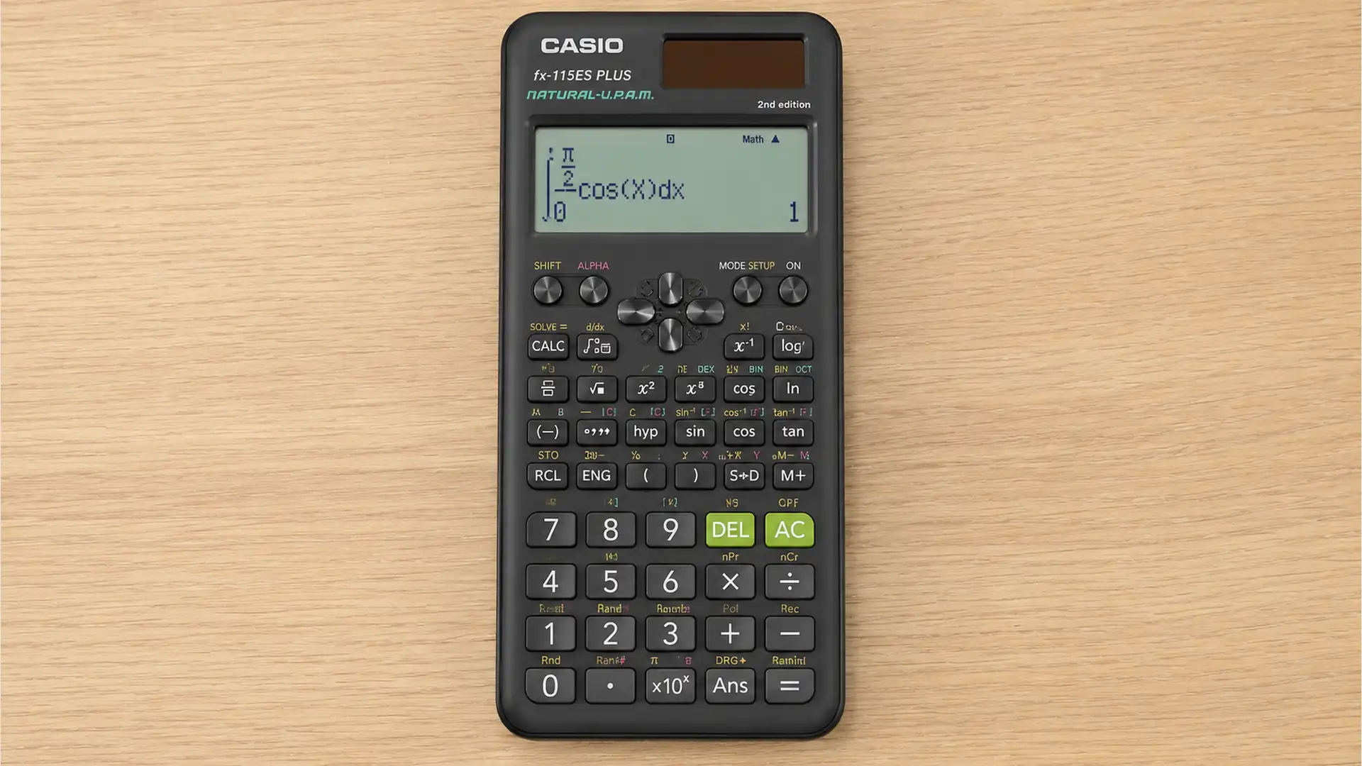 scientific calculator on a light wood desk with integral equation on screen and all keys clearly visible.
