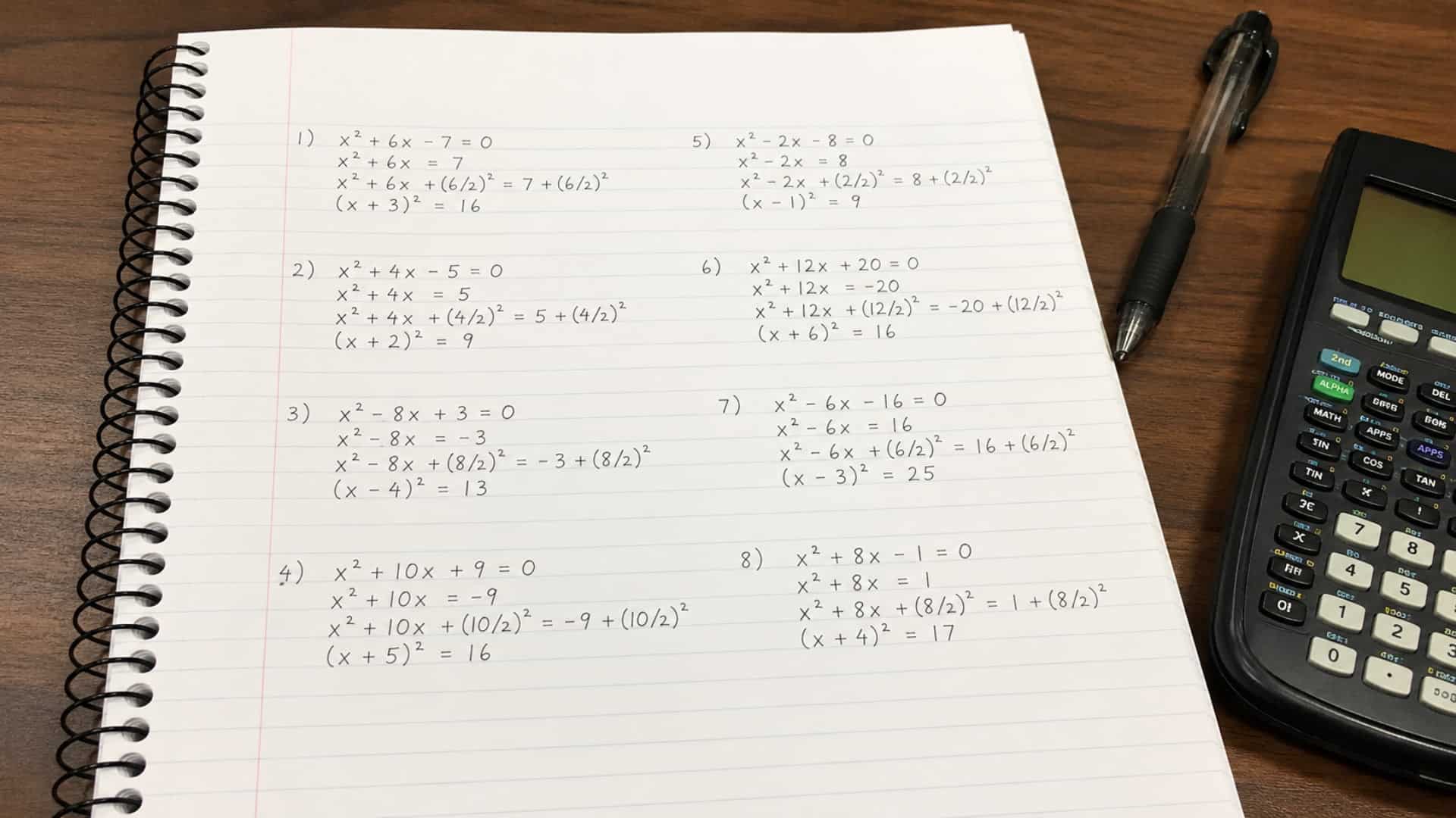 completing the square practice problems in a notebook with calculator and pen on desk, realistic math study setup