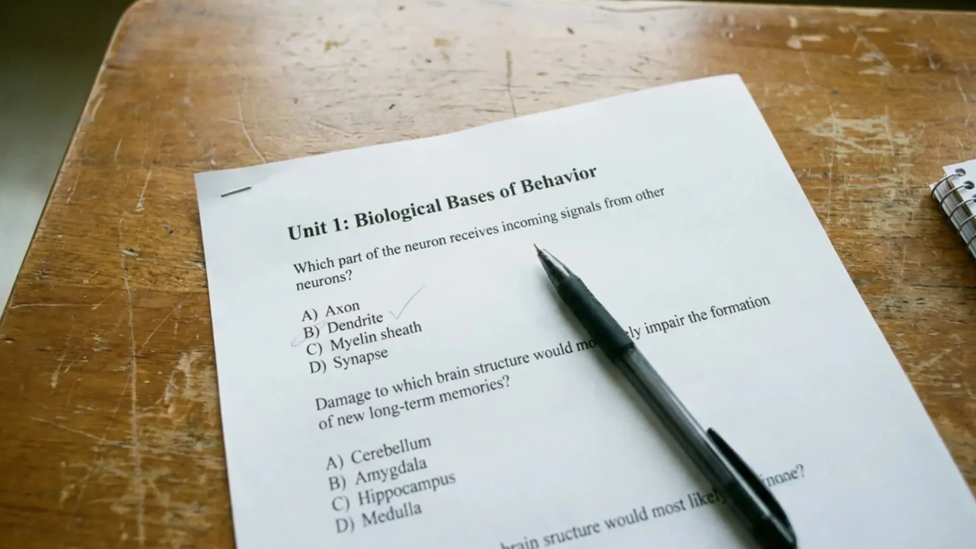printed ap psychology practice questions on a wooden desk with a pen marking the correct answer